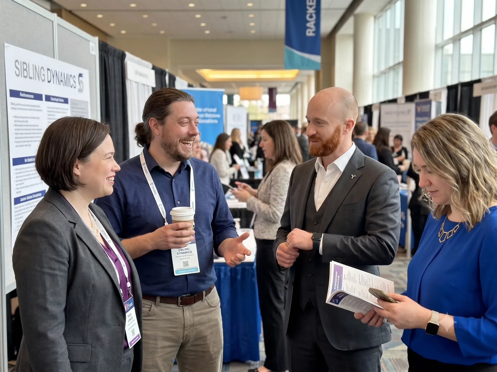 The Sibling Dynamics team talking with attendees at a conference